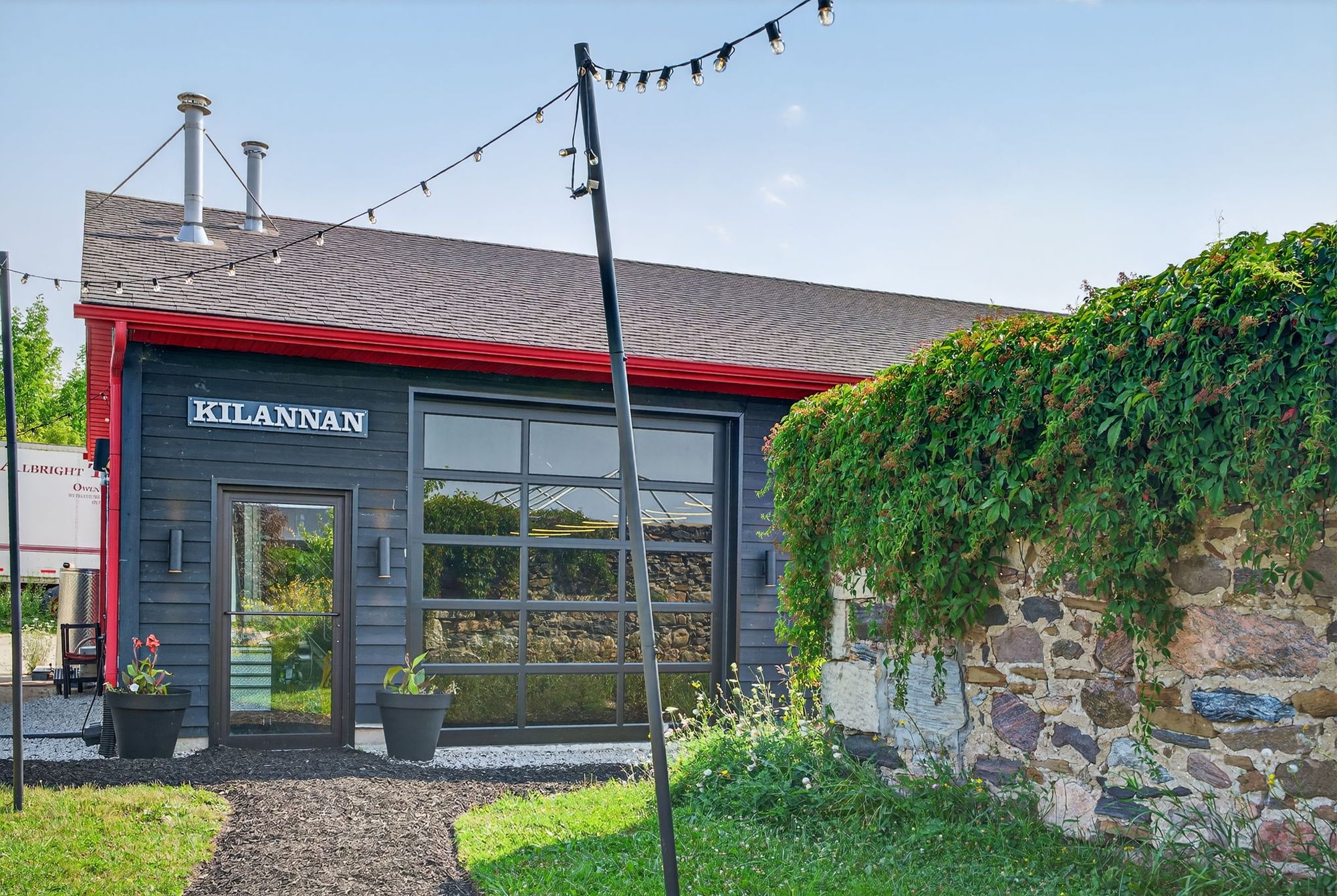 The Kilannan taproom's glass garage door and string lights