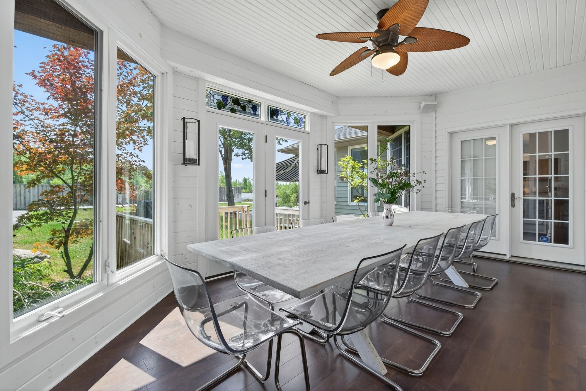 The sunroom's long table with glass doors on three sides