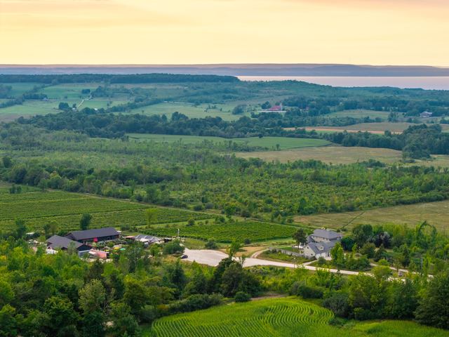 Coffin Ridge from the air at sunset: the winery, the vineyard and both houses, with Georgian Bay on the horizon